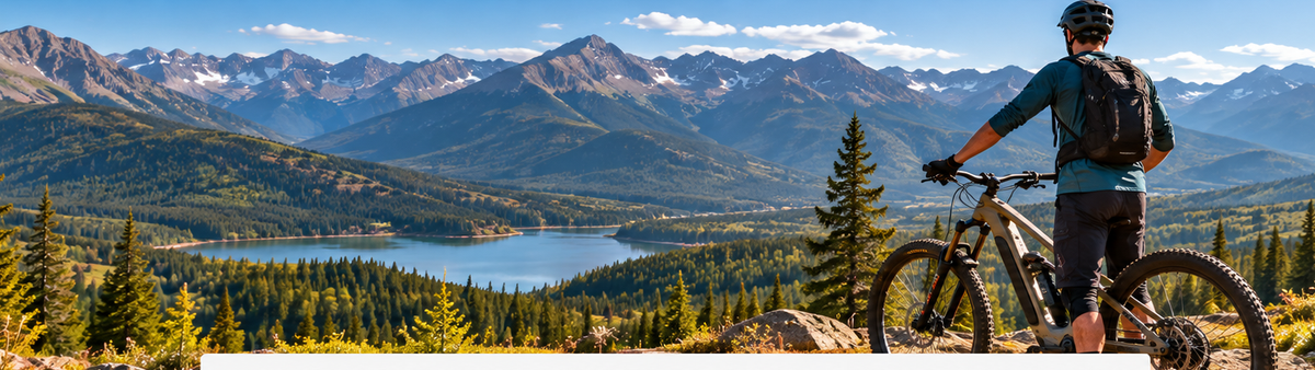 E-MTB rider overlooking mountain trails and a lake while choosing a bike for real riding needs
